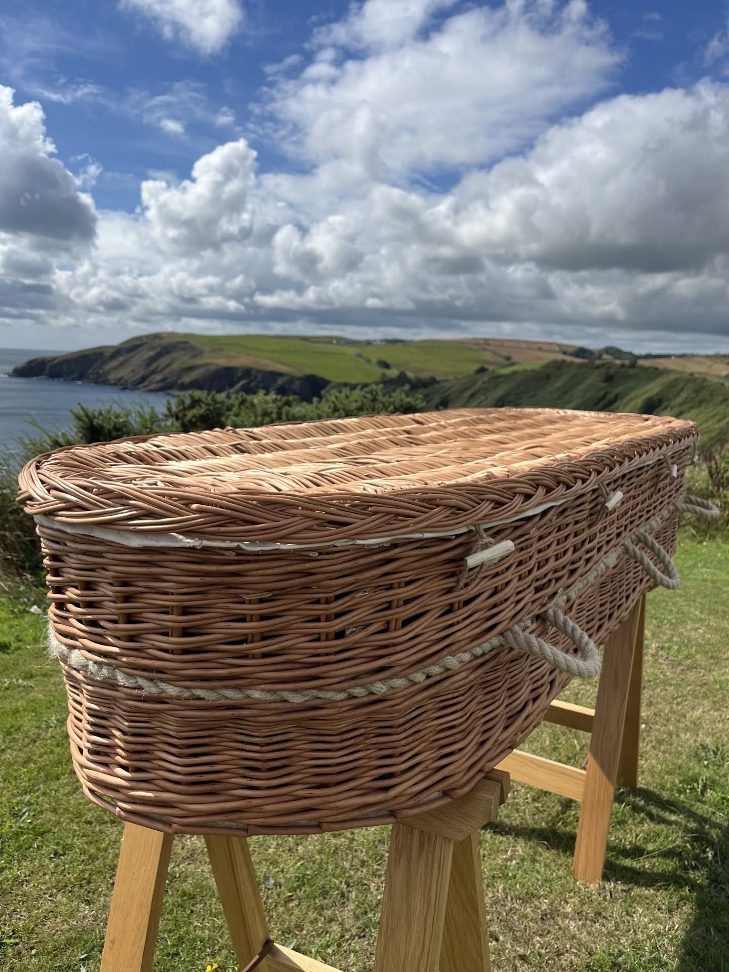 A handwoven willow coffin resting above the Isle of Man coast